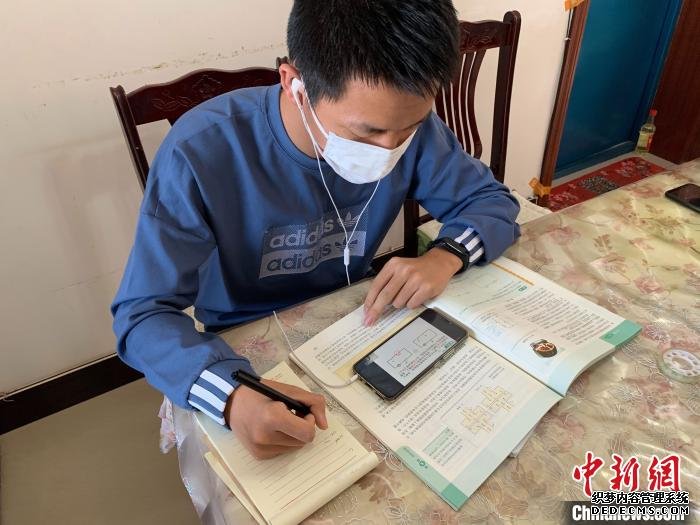 宁夏青铜峡高级中学高二学生闫翔宇在家中通过手机“云校家”收听直播课程。　李佩珊 摄